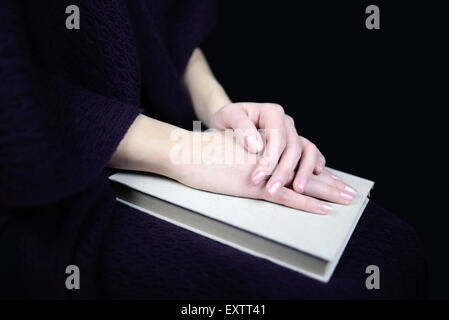 female hands on a closed book Stock Photo