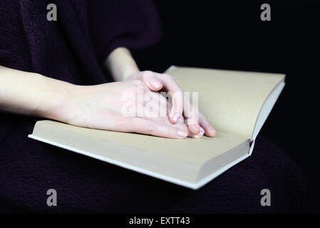 female hands on a closed book Stock Photo