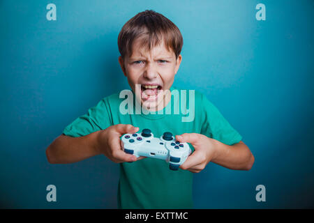 Teen boy screaming open mouth holds the emotions game joystick o Stock Photo