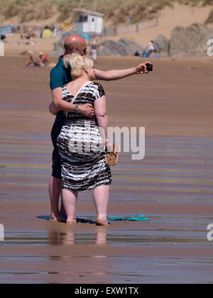Middle aged couple taking a selfie at the beach, Woolacombe, Devon, UK Stock Photo