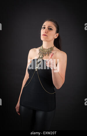 Beautiful woman doing different expressions in different sets of clothes: gun sign Stock Photo