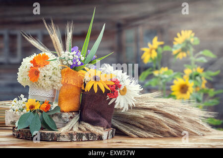 Wedding decoration in rustic style. Still life with summer flowers in a bags and ears of wheat. Stock Photo