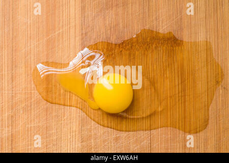 Broken egg on woody plank  from above view Stock Photo