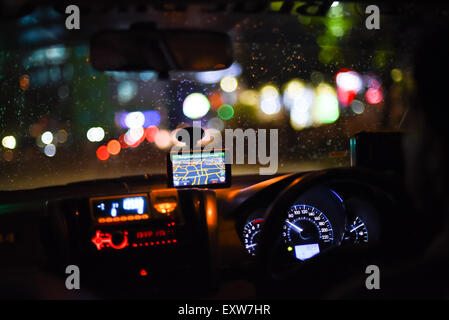 Taxi dashboard and interiors during night trip in Jakarta, Indonesia. Stock Photo