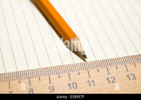 Notepad with a recording sheet, pencil and wooden ruler on the old tissue Stock Photo