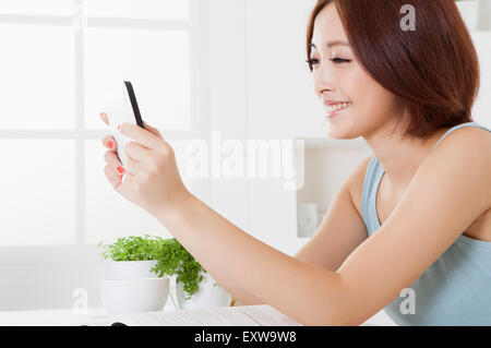 Young woman holding mobile phone with smile, Stock Photo