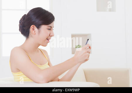 Young woman holding mobile phone with smile, Stock Photo