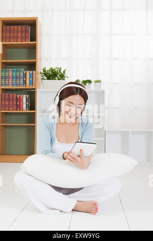 Young woman sitting and wearing headphone with smile, Stock Photo