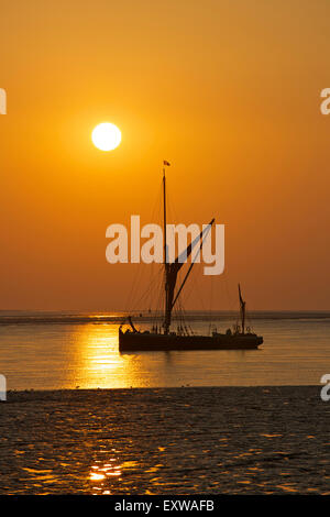 Swale Estuary, Kent, UK. 17th July 2015: UK Weather. Sunrise over the Thames sailing barge 'Orinoco' moored near the entrance to Faversham creek as another warm summers day starts. The Orinoco was built in 1895 and is one of only a handful of seaworthy Thames sailing barges left, and is available for private charter Credit:  Alan Payton/Alamy Live News Stock Photo