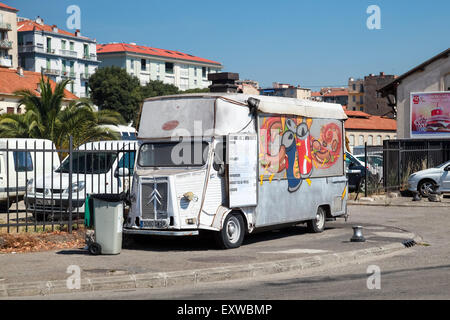 Ajaccio, France - June 30, 2015: Old white Citroen H Van, light truck converted to catering trailer with colorful advertising gr Stock Photo