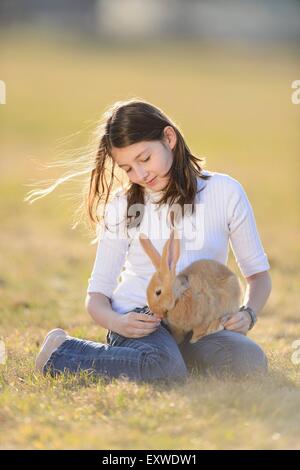 Teenage girl with her rabbit on a meadow, Upper Palatinate, Bavaria, Germany, Europe Stock Photo