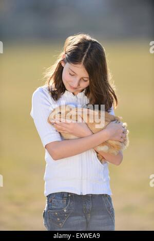 Teenage girl with her rabbit on a meadow, Upper Palatinate, Bavaria, Germany, Europe Stock Photo