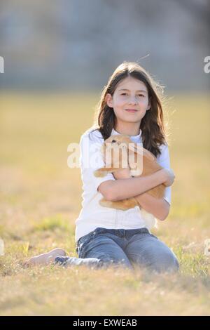 Teenage girl with her rabbit on a meadow, Upper Palatinate, Bavaria, Germany, Europe Stock Photo
