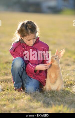 Girl with her rabbit on meadow, Upper Palatinate, Bavaria, Germany, Europe Stock Photo