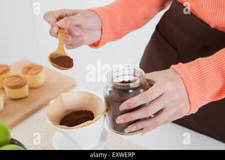 Young woman making coffee in the kitchen, Stock Photo