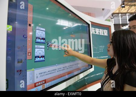 Shanghai, China. 17th July, 2015. A visitor experiences a 'touching blackboard' during the Mobile World Congress Shanghai in Shanghai, east China, July 17, 2015. The Mobile World Congress Shanghai was held here from July 15 to July 17. Credit:  Liu Xiaojing/Xinhua/Alamy Live News Stock Photo