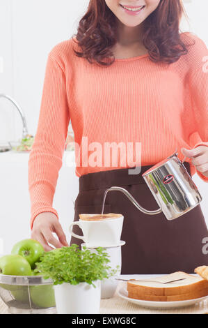 Young woman making coffee with smile, Stock Photo
