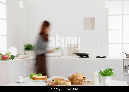 Young woman making breakfast in the kitchen, Stock Photo