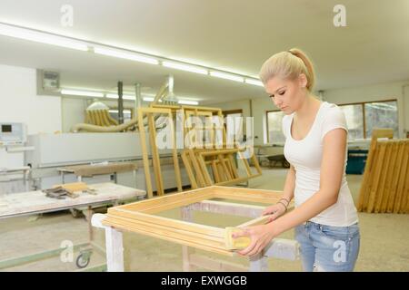 Young woman in a carpentry working on a window frame Stock Photo