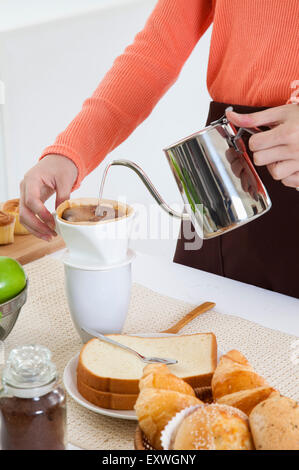Young woman making coffee in the kitchen, Stock Photo