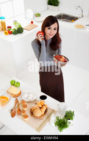 Young woman holding apples and smiling at the camera, Stock Photo
