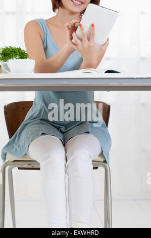 Young woman sitting and using touch pad with smile, Stock Photo