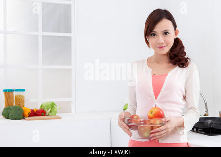 Young woman holding apples and smiling at the camera, Stock Photo