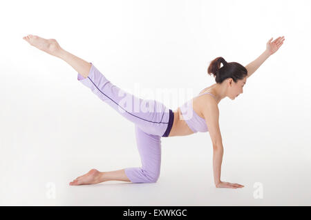 Woman practicing yoga with one leg in the air, Stock Photo