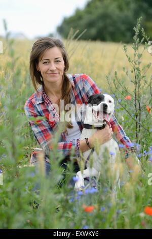 Woman with a mongrel dog on a meadow, Bavaria, Germany, Europe Stock Photo
