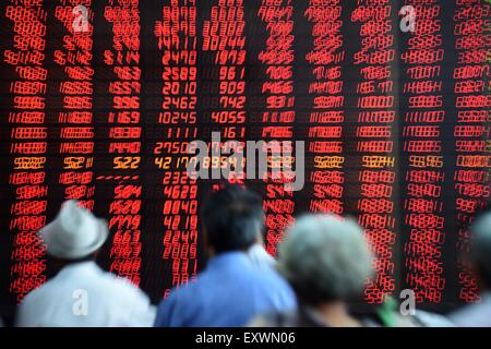 Shenyang, China. 17th July, 2015. Investors look through stock information at a trading hall in a securities firm in Shenyang, capital of northeast China's Liaoning Province, July 17, 2015. Chinese shares surged more than 3 percent on Friday, with the benchmark Shanghai Composite Index up 3.51 percent to close at 3,957.35 points. The smaller Shenzhen Component Index soared 5.24 percent to close at 13,004.96 points. The ChiNext Index, tracking China's Nasdaq-style board of growth enterprises, climbed 5.95 percent to end at 2,783.32 points. Credit:  Xinhua/Alamy Live News Stock Photo