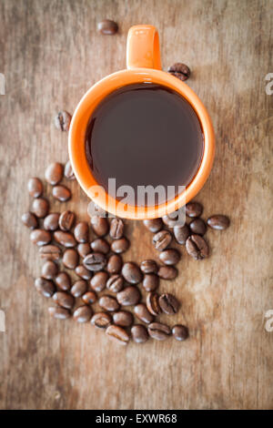 Coffee beans with coffee cup on wooden table, stock photo Stock Photo