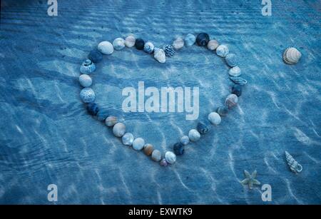 Heart made of shells in pool Stock Photo