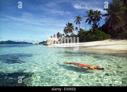 Woman swimming in indian ocean, Pointe Source d'Argent, La Digue, Seychelles Stock Photo