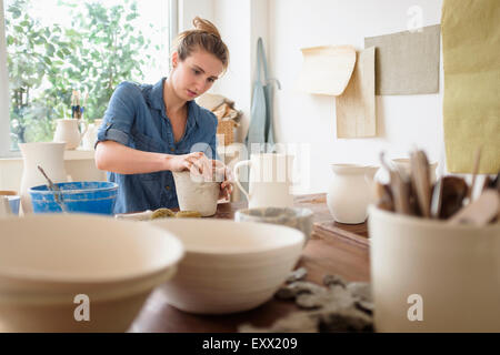 Young woman making pottery in studio Stock Photo