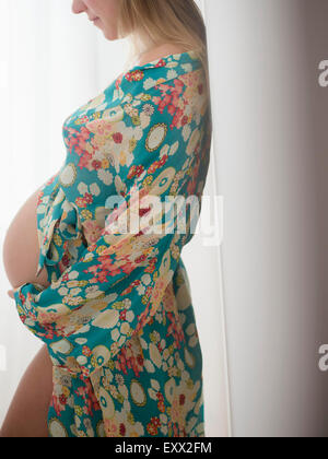 Pregnant woman in colorful dressing gown Stock Photo