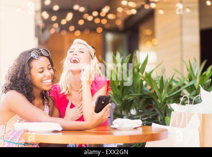 Female friends using smart phone in cafe Stock Photo