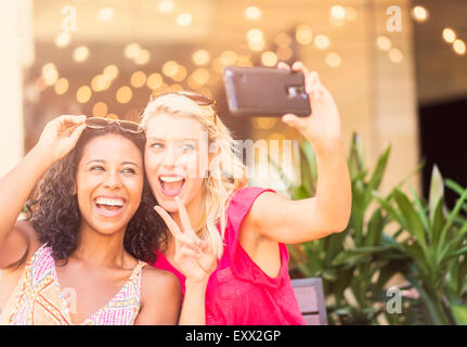 Female friends taking selfie with smart phone in cafe Stock Photo