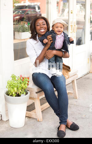 Portrait of smiling woman holding son (12-17 months) Stock Photo