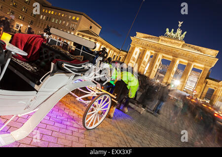 Horse carts in front of illuminated Brandenburg Gate Stock Photo