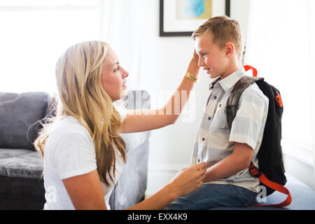 Mother preparing son (6-7) for school Stock Photo