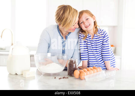 Portrait of girl (4-5) spending time with mom in kitchen Stock Photo