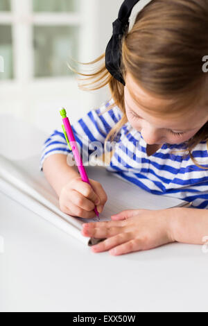 Girl (4-5) drawing in living room Stock Photo