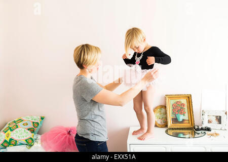 Woman helping daughter (4-5) with costume Stock Photo