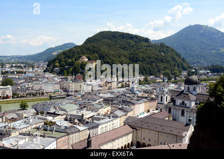 The tree-covered hillside of Kapuzinerberg stands in the middle of Salzburg city. The Salzach river runs through the city Stock Photo