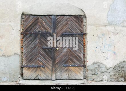 Wall of old abandoned building with wooden doors Stock Photo