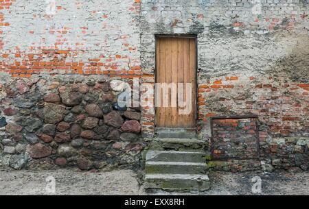 Wall of old abandoned building with wooden doors Stock Photo