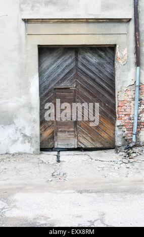 Wall of old abandoned building with wooden doors Stock Photo