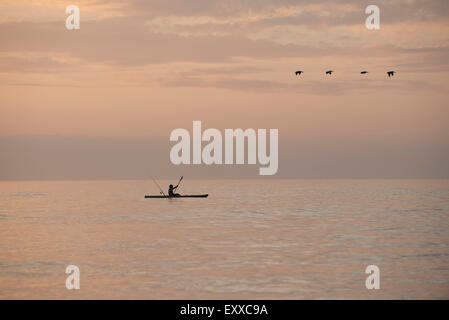 Person kayaking at sunset Stock Photo