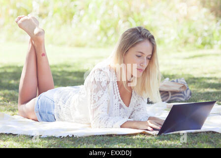 Woman using netbook outdoors Stock Photo