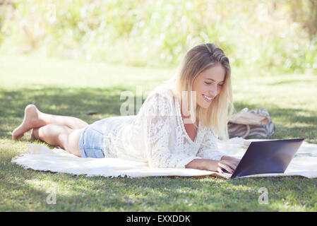 Woman using laptop outdoors Stock Photo